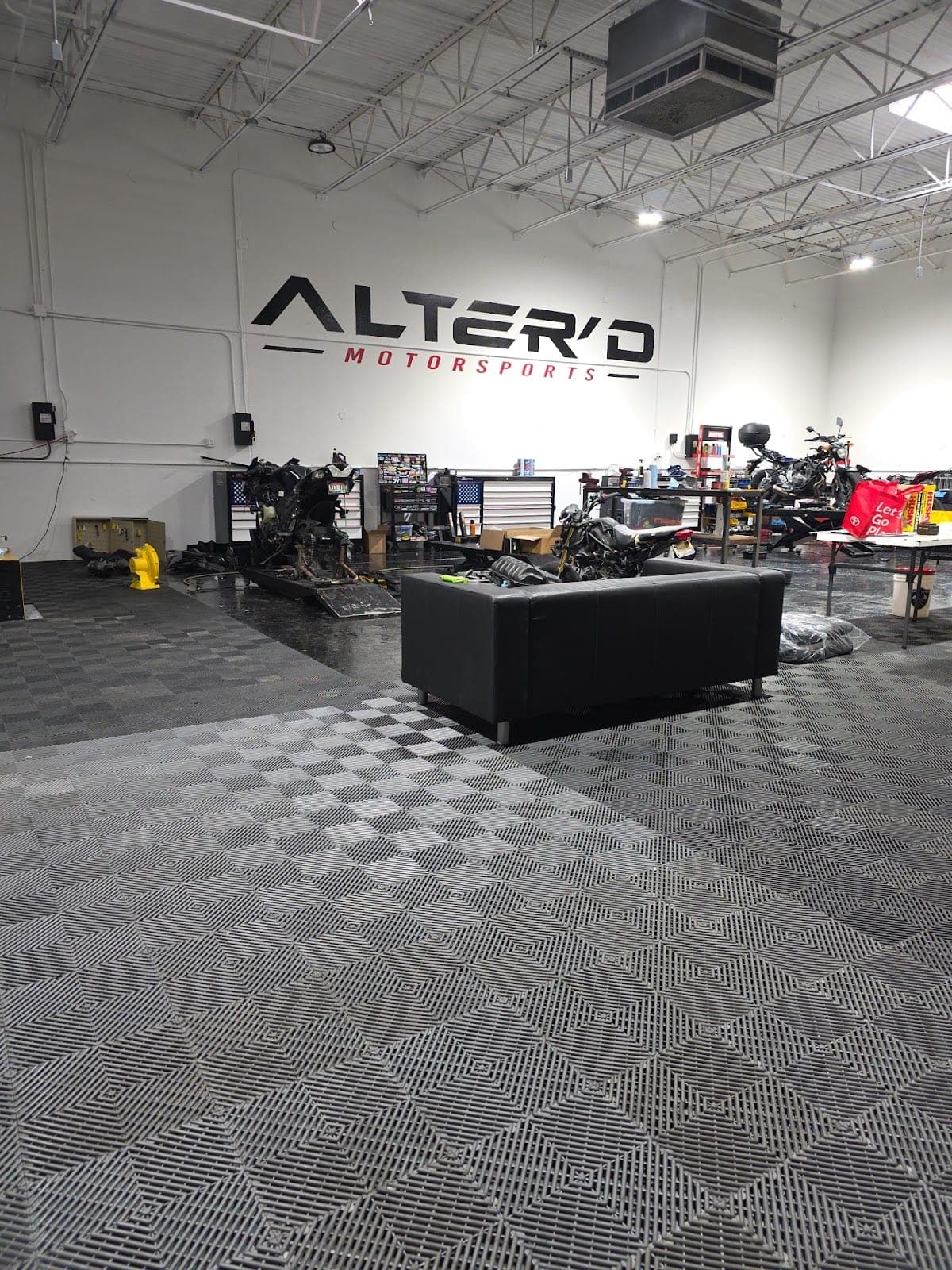 Inside the Alter'd Motorsports shop in Carrollton: the bay, the lifts and the sign on the wall